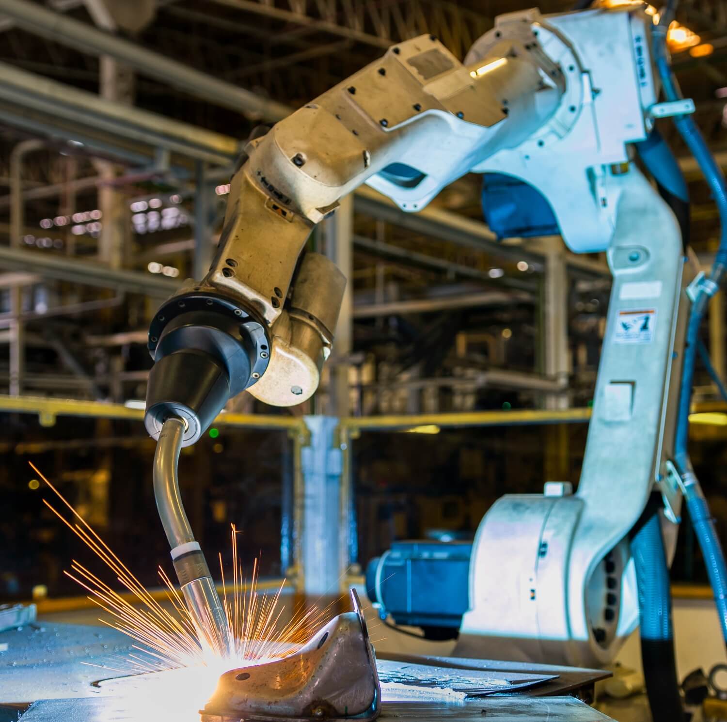 A robotic arc welder creates sparks